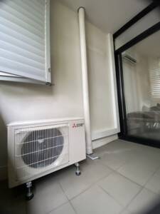 Split system Mitsubishi outdoor unit on a balcony