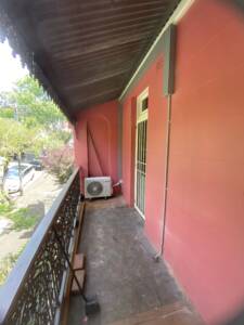 AC condenser unit installed in a corner of a balcony