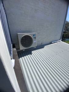 Outdoor AC unit installed on wall brackets